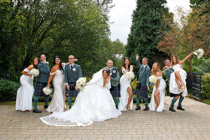 a row of people posing for a photo in front of trees.