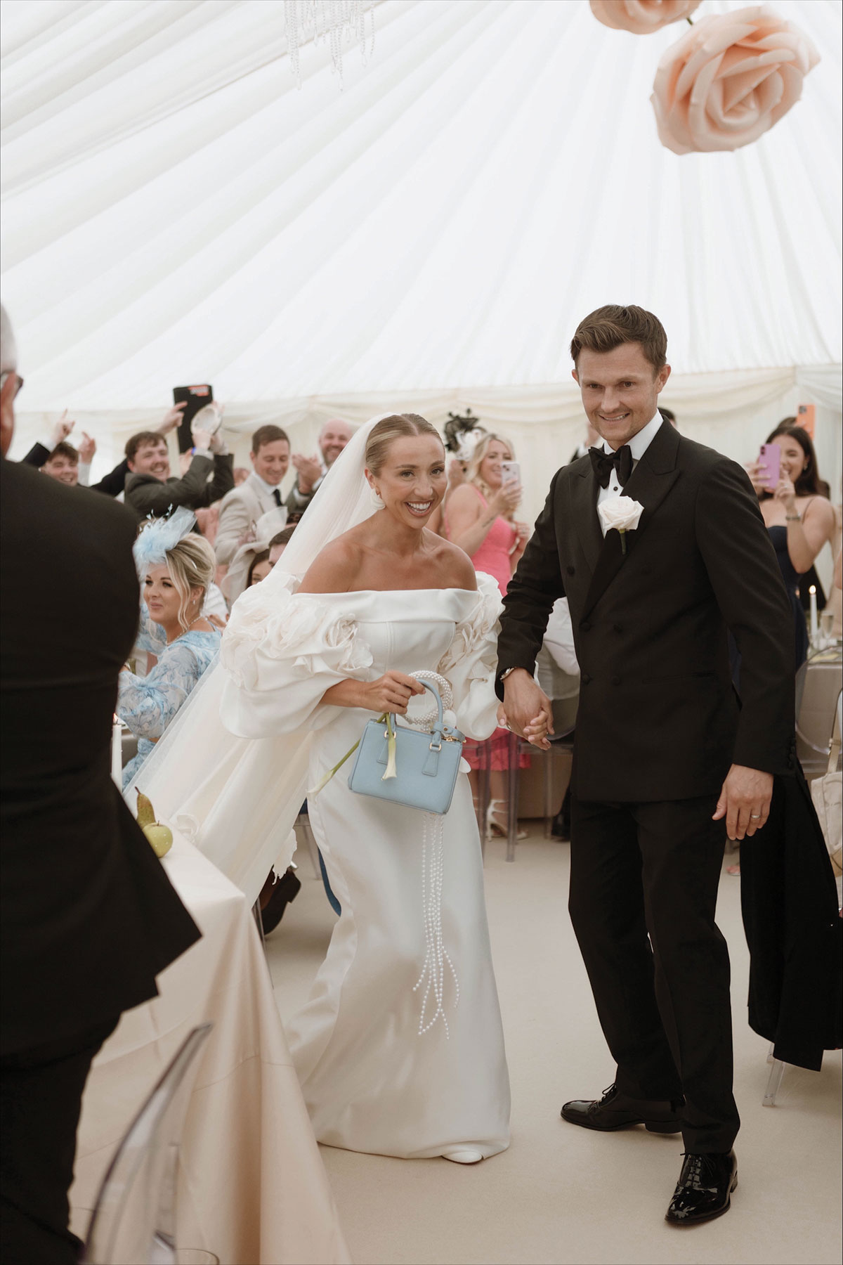 Bride and groom arriving hand in hand for wedding dinner inside a luxury marquee reception in Ayrshire