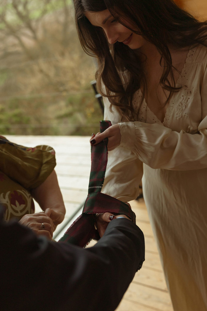 close up of bride and groom's hands doing a handfasting ritual