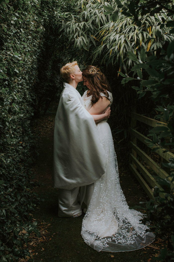 bride kisses wife on forehead in green space at cambo estate