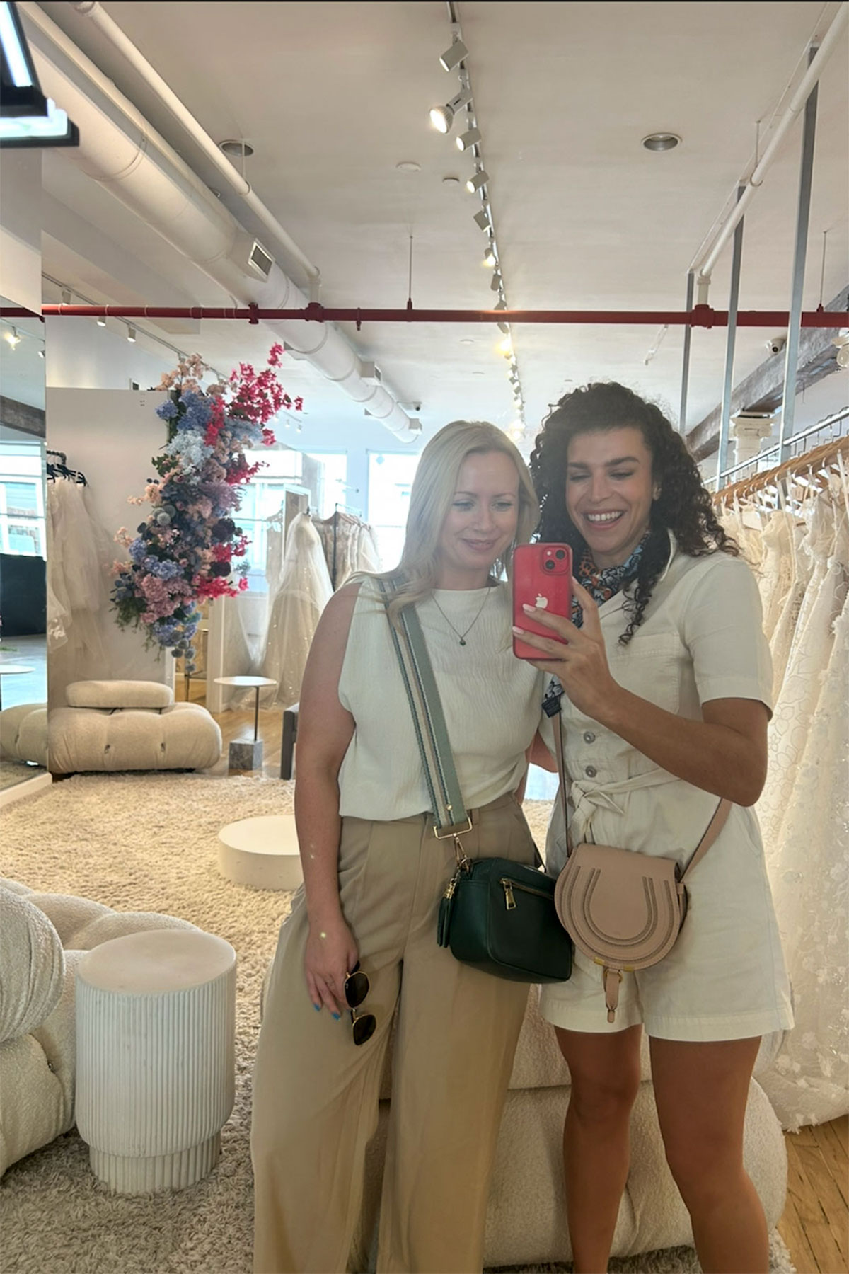 two girls take a selfie in the mirror at kleinfeld in new york