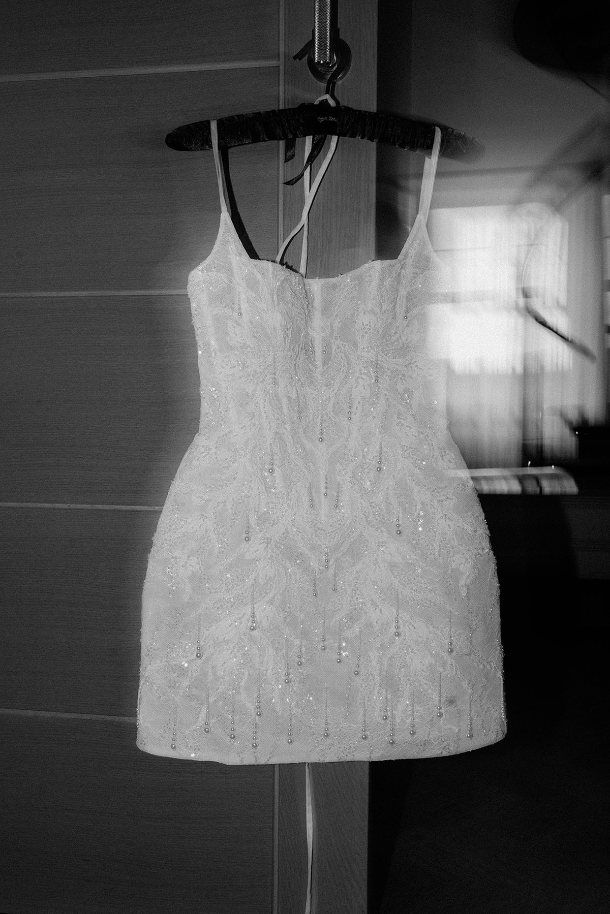 Beaded bridal mini dress hanging in hotel room ahead of Brisbane House Hotel wedding morning