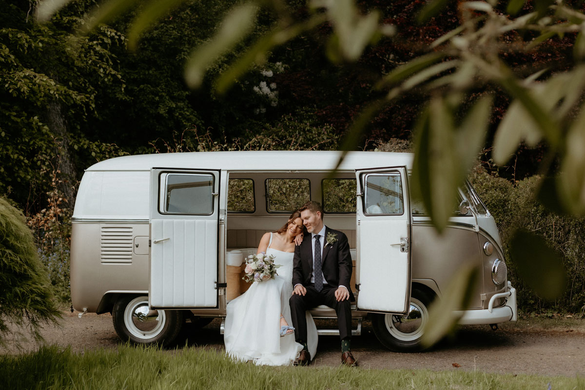 Newlyweds sitting together in a vintage campervan during their wedding at The Byre at Inchyra.