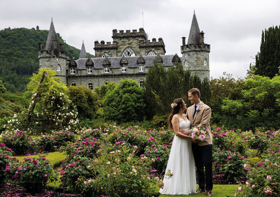 couple looking at one another on wedding day in front of castle venue