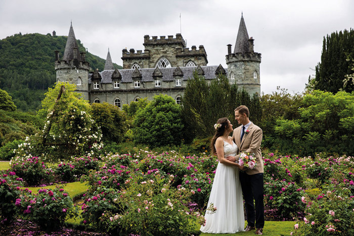 couple looking at one another on wedding day in front of castle venue