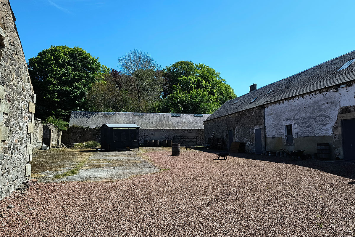 Gravel courtyard surrounded by traditional stone barns at Cormiston Farm wedding venue in the Scottish Borders.