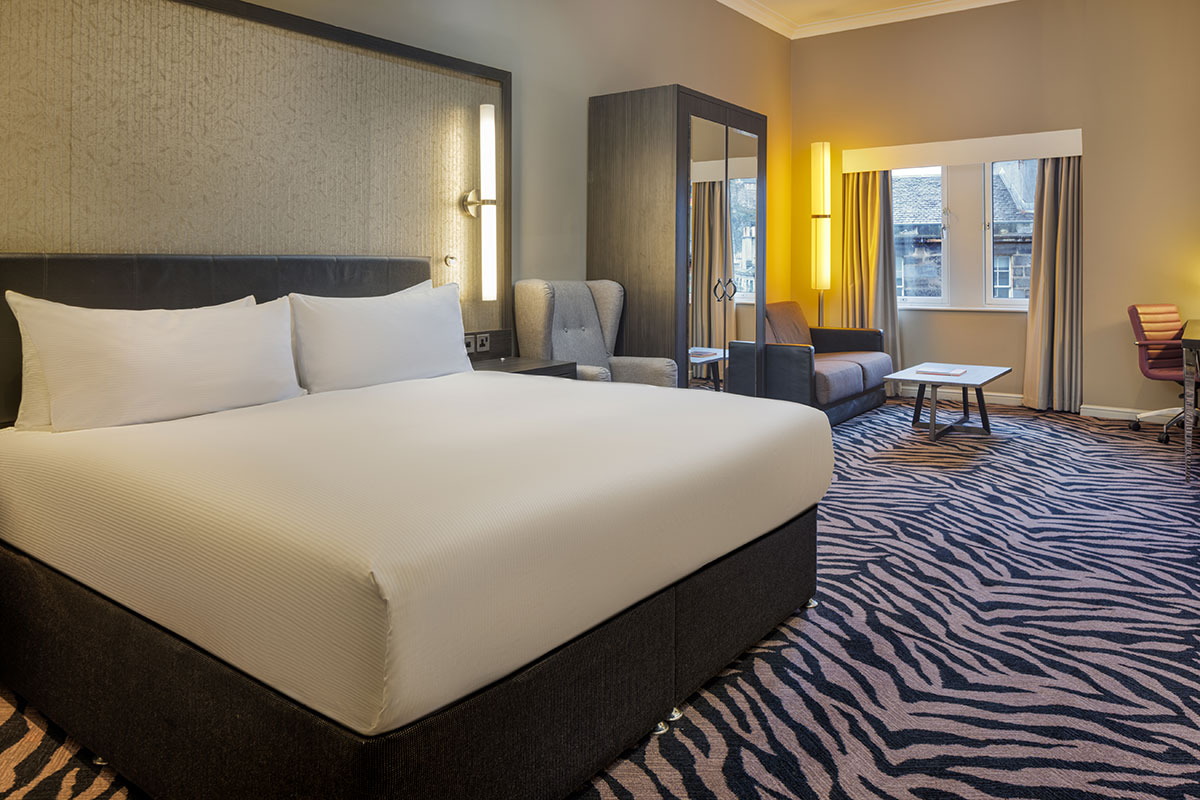 DoubleTree by Hilton Edinburgh City Centre hotel bedroom with king bed and seating area for wedding guests