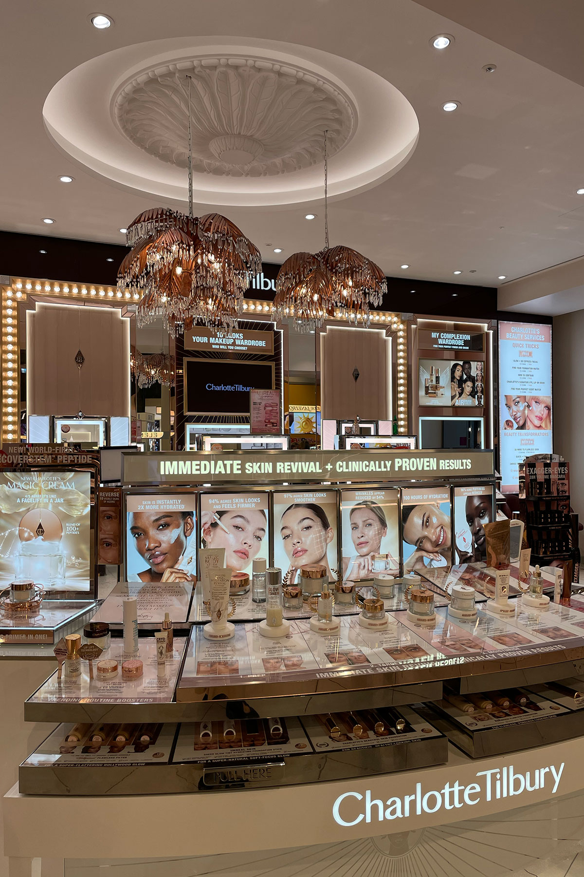 Charlotte Tilbury beauty counter at H beauty Silverburn displaying skincare and makeup products beneath decorative lighting.