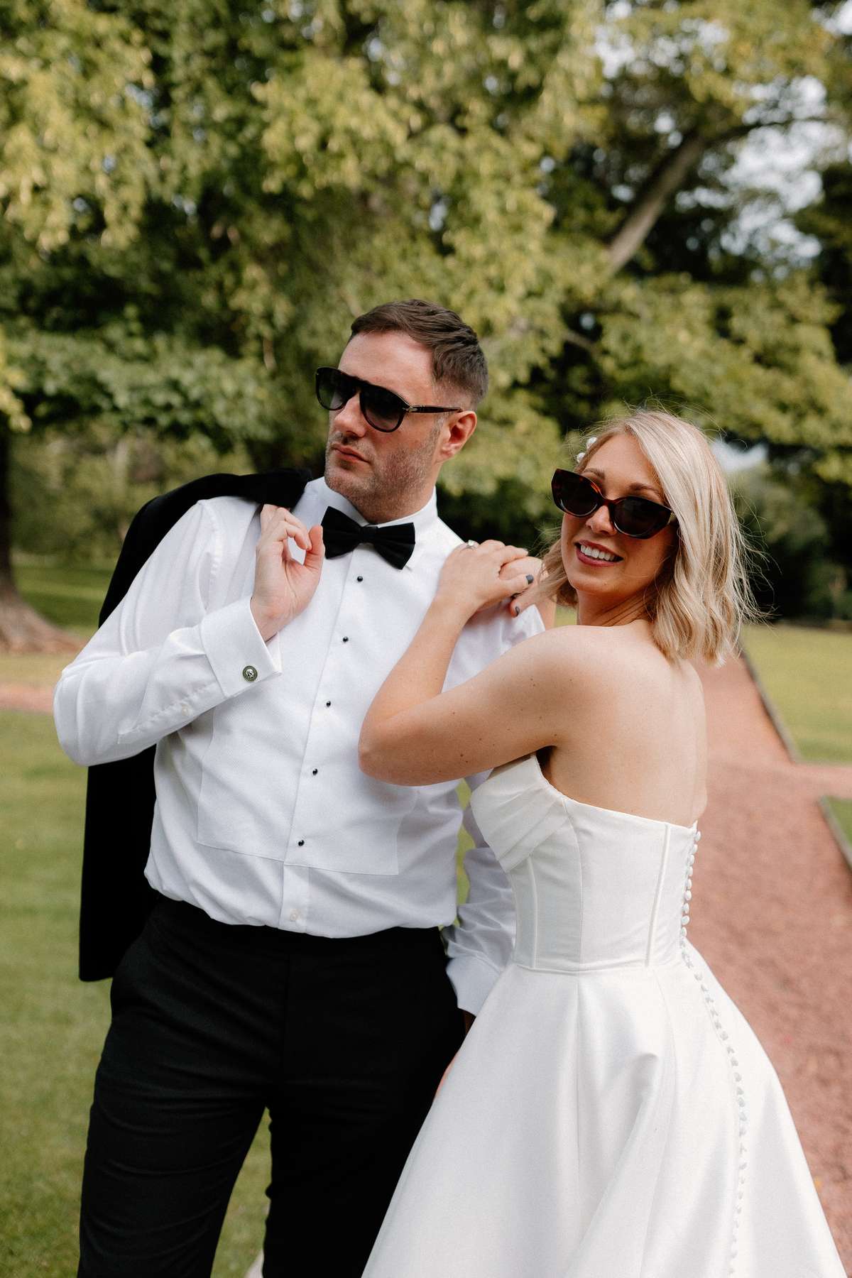 Kara and Rory wear sunglasses during playful wedding portraits in the grounds of Prestonfield House.