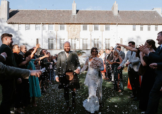 Guests throw confetti on newlywed couple