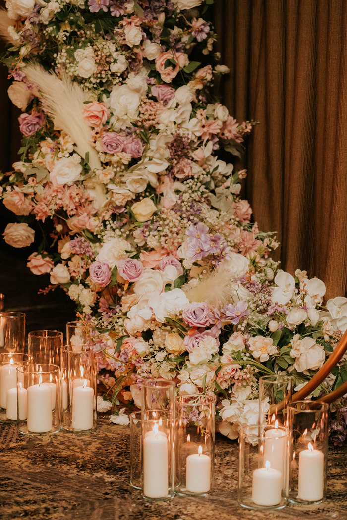 A large floral arrangement with candles.