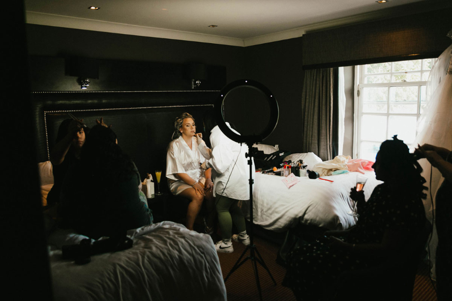 A Bride In A Bedroom Getting Her Makeup Done