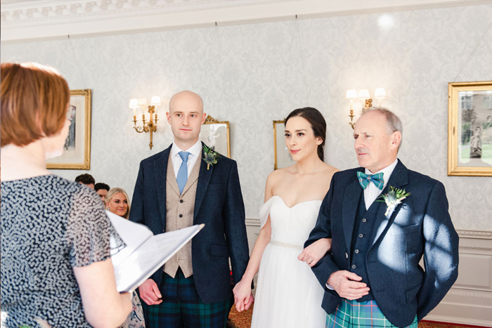 Bride's father walks her down the aisle to stand next to groom