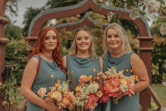 Image of the bridesmaids in blue dresses holding bouquet