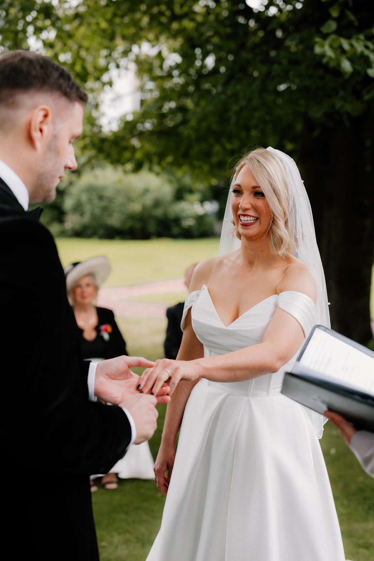 Kara places Rory’s wedding ring on his finger during their outdoor ceremony at Prestonfield House in Edinburgh.