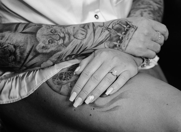 A black and white photo of a woman's hands resting on her leg