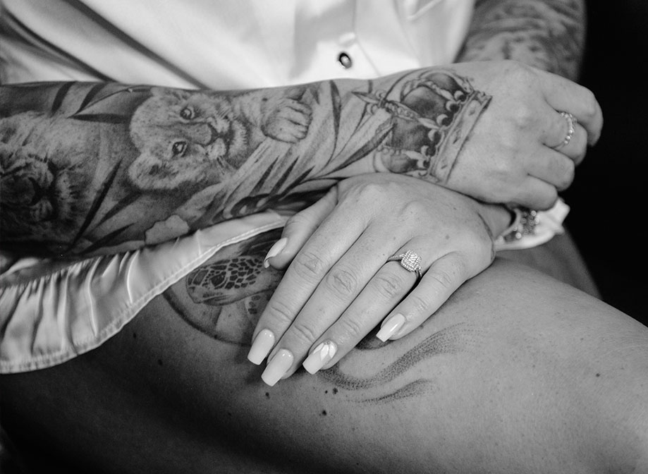 A black and white photo of a woman's hands resting on her leg