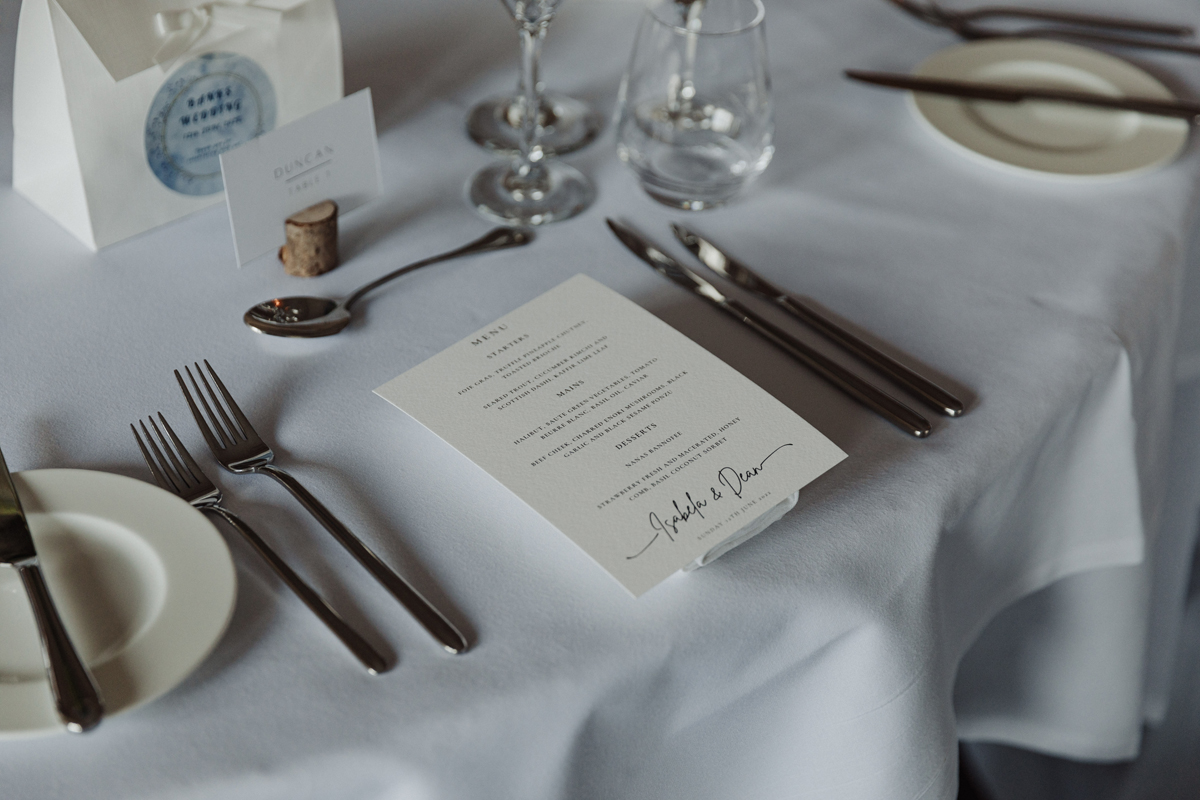 Close-up of elegant wedding place setting with printed menu and favours at Dean Banks, The Caledonian