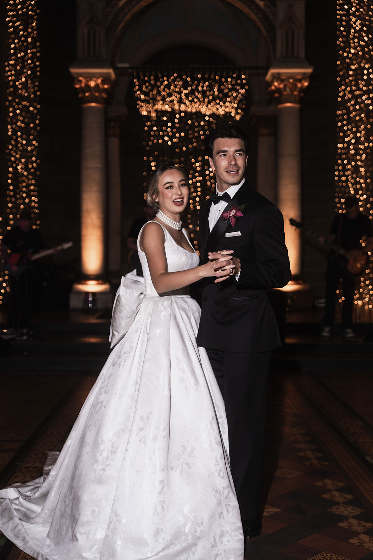 Bride and groom sharing their first dance beneath twinkling fairy lights inside Mansfield Traquair