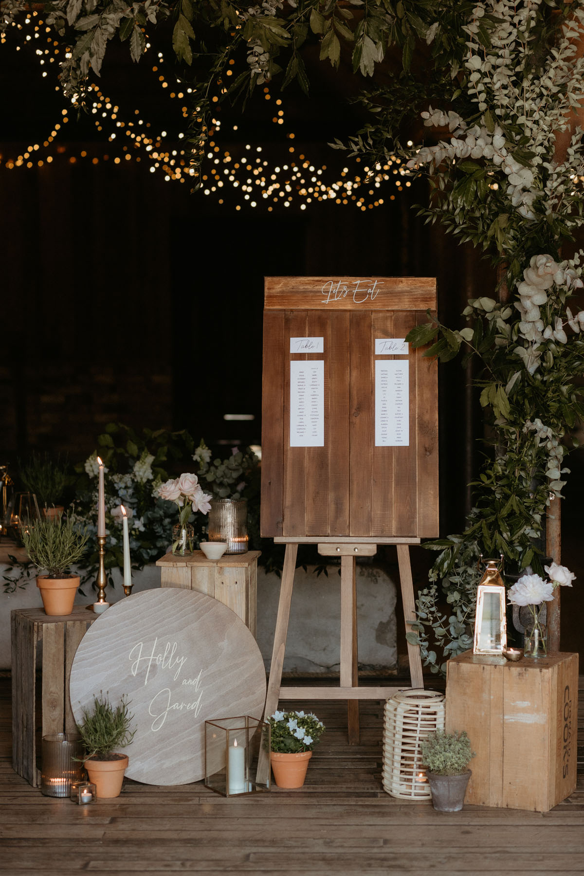 Rustic wedding table plan at The Byre at Inchyra, styled with greenery, candles, flowers and wooden signag