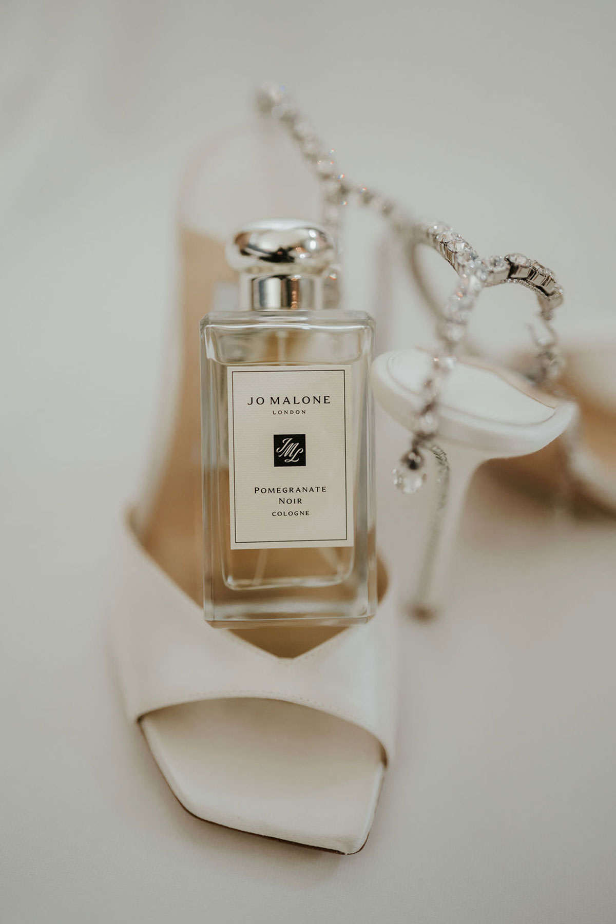 Jo Malone perfume bottle displayed with the bride’s white wedding shoes and jewellery.