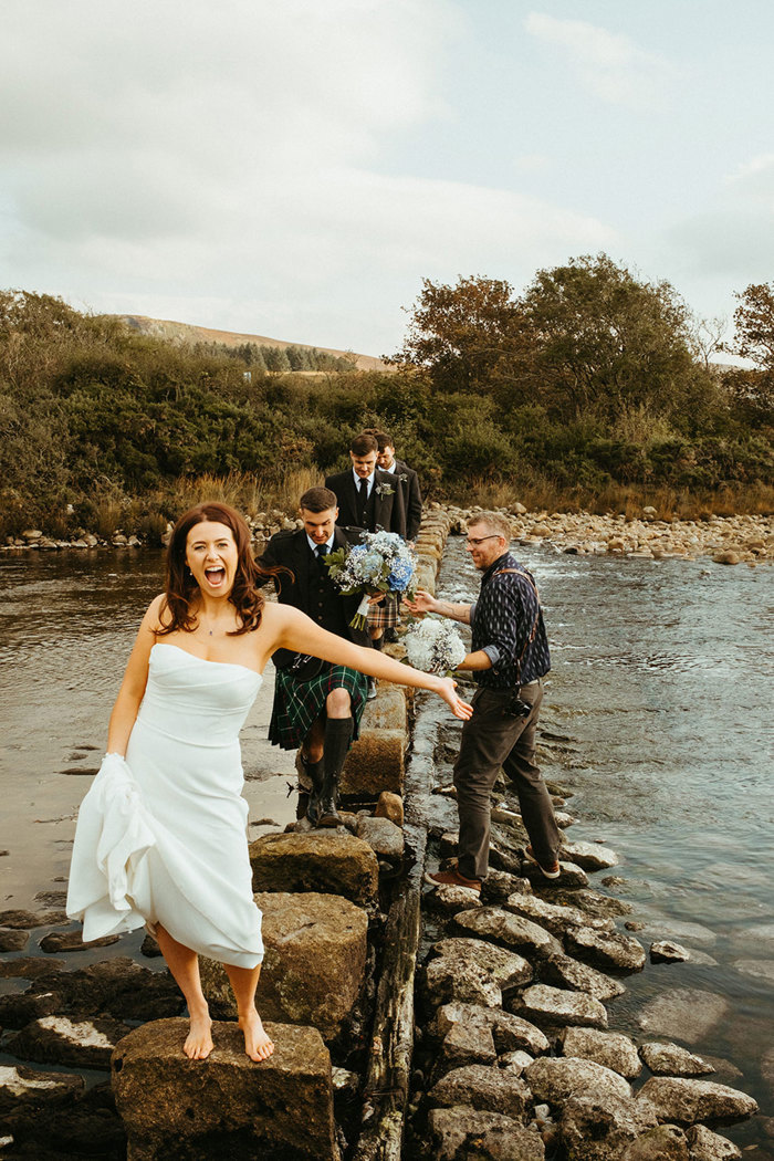 bride laughs as guests walk along dougarie boathouse steps