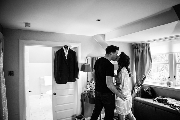 Black and white photo of the couple kissing before going to get ready