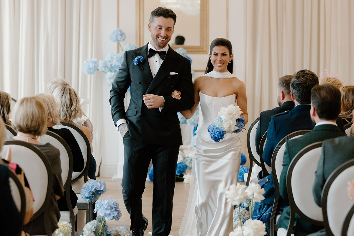 Bride and groom walking back up the aisle after ceremony at The Exchange Glasgow, blue hydrangea aisle flowers