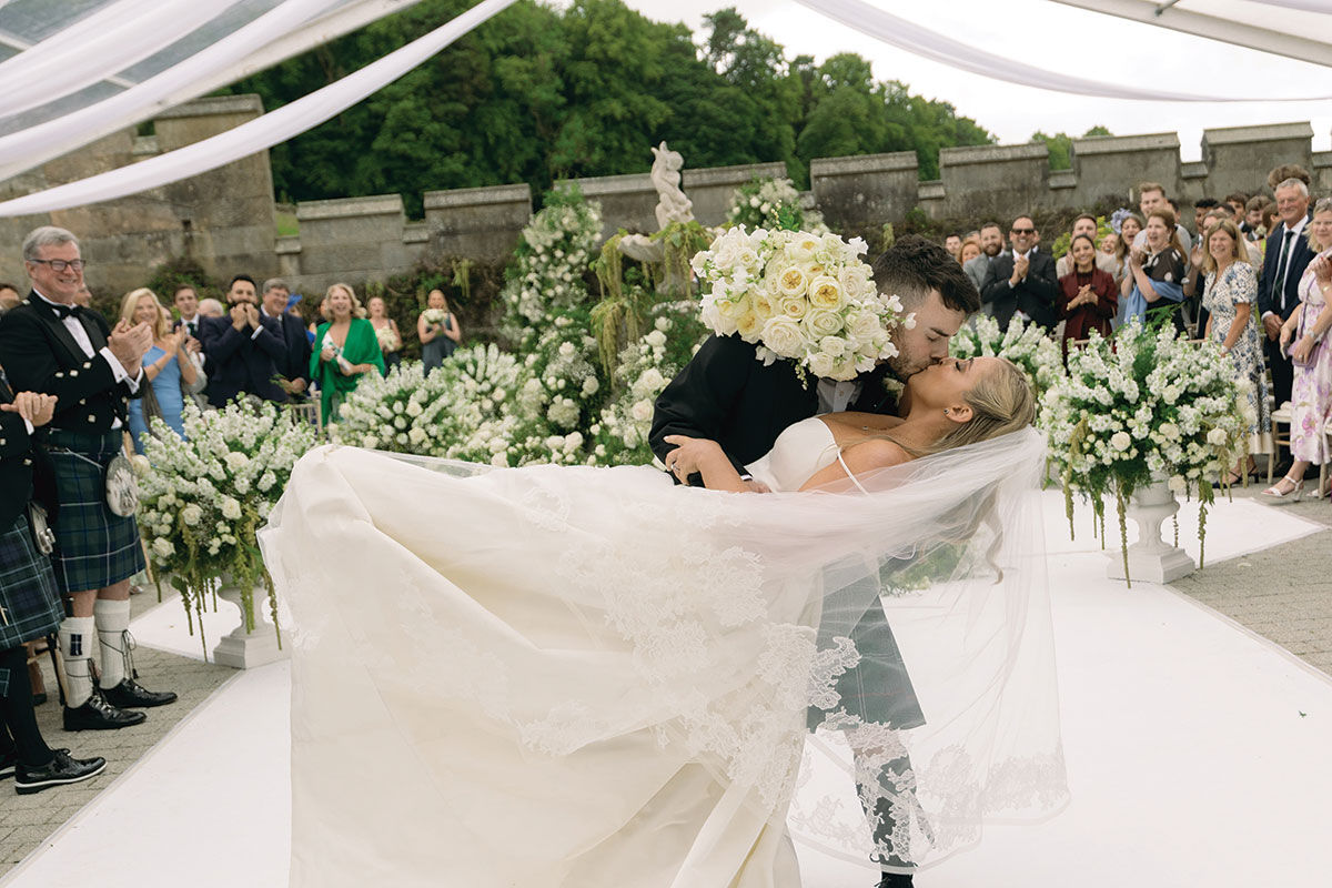 Bride and groom dip kiss at Dundas Castle outdoor wedding ceremony