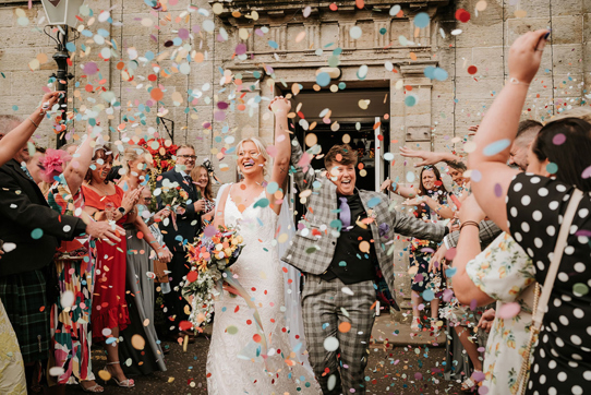 Couple emerge from venue to a confetti shower