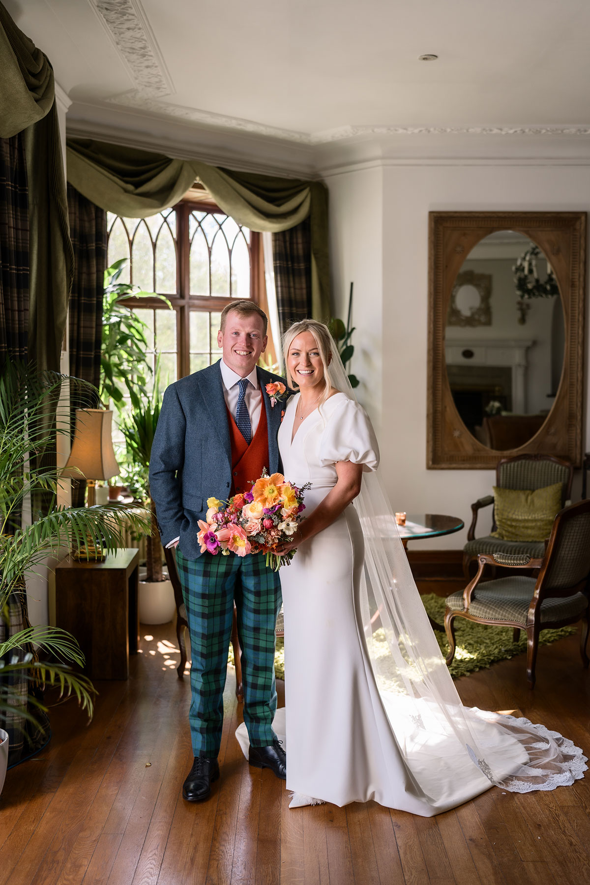 bride and groom smile for a photograph indoors at achnagairn castle on wedding day