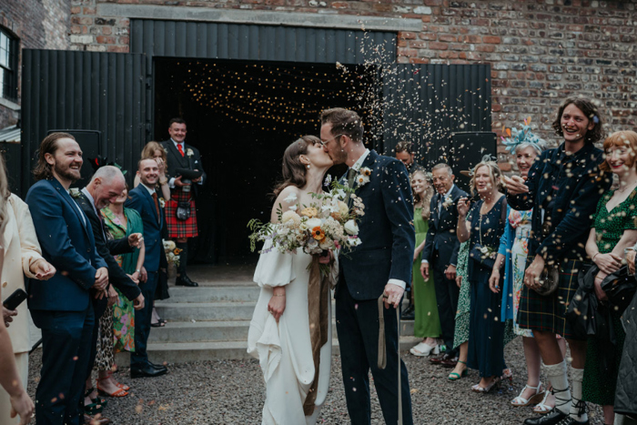 Couple kiss as guests throw confetti