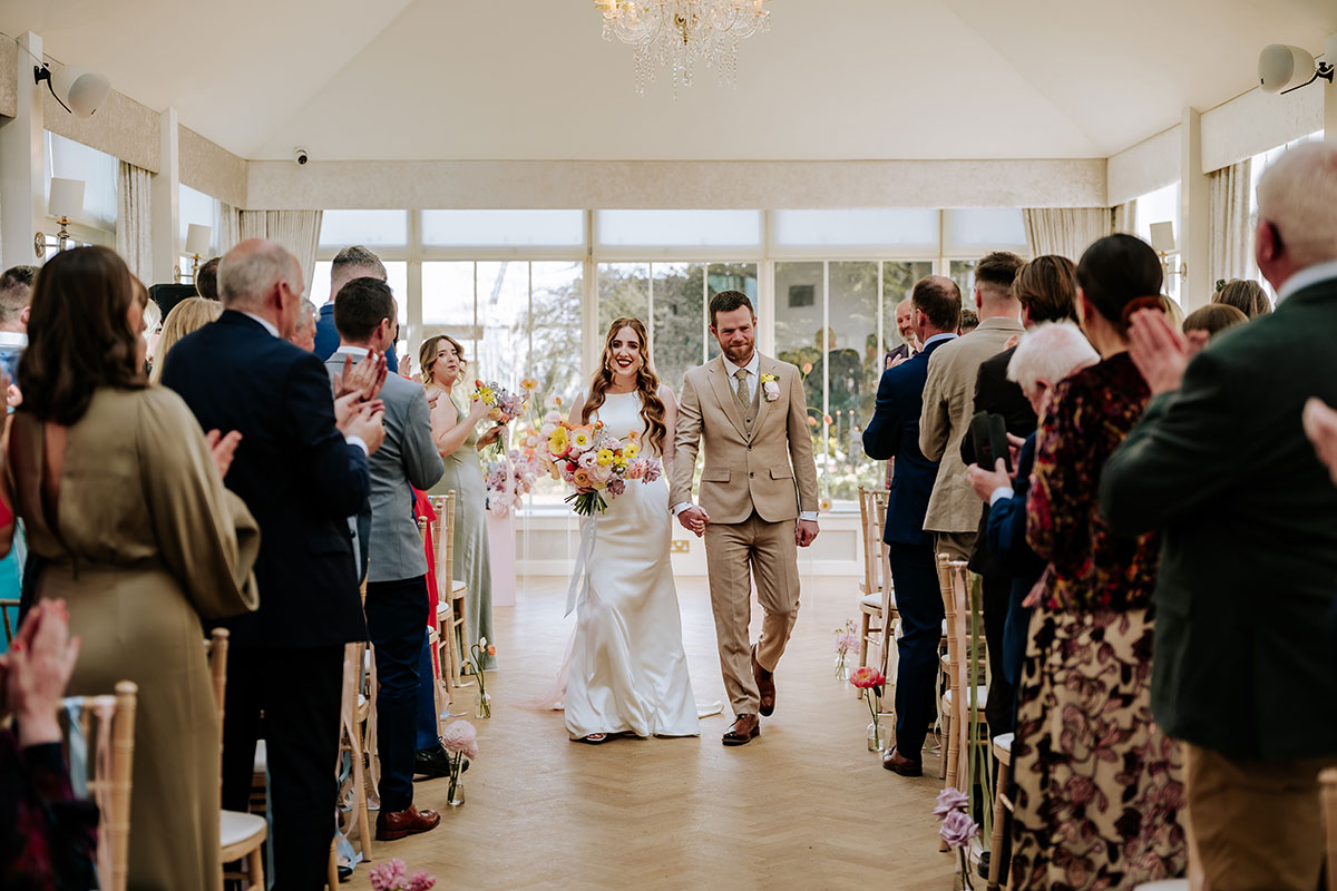 a bride and groom walking up aisle at Carlowrie Castle