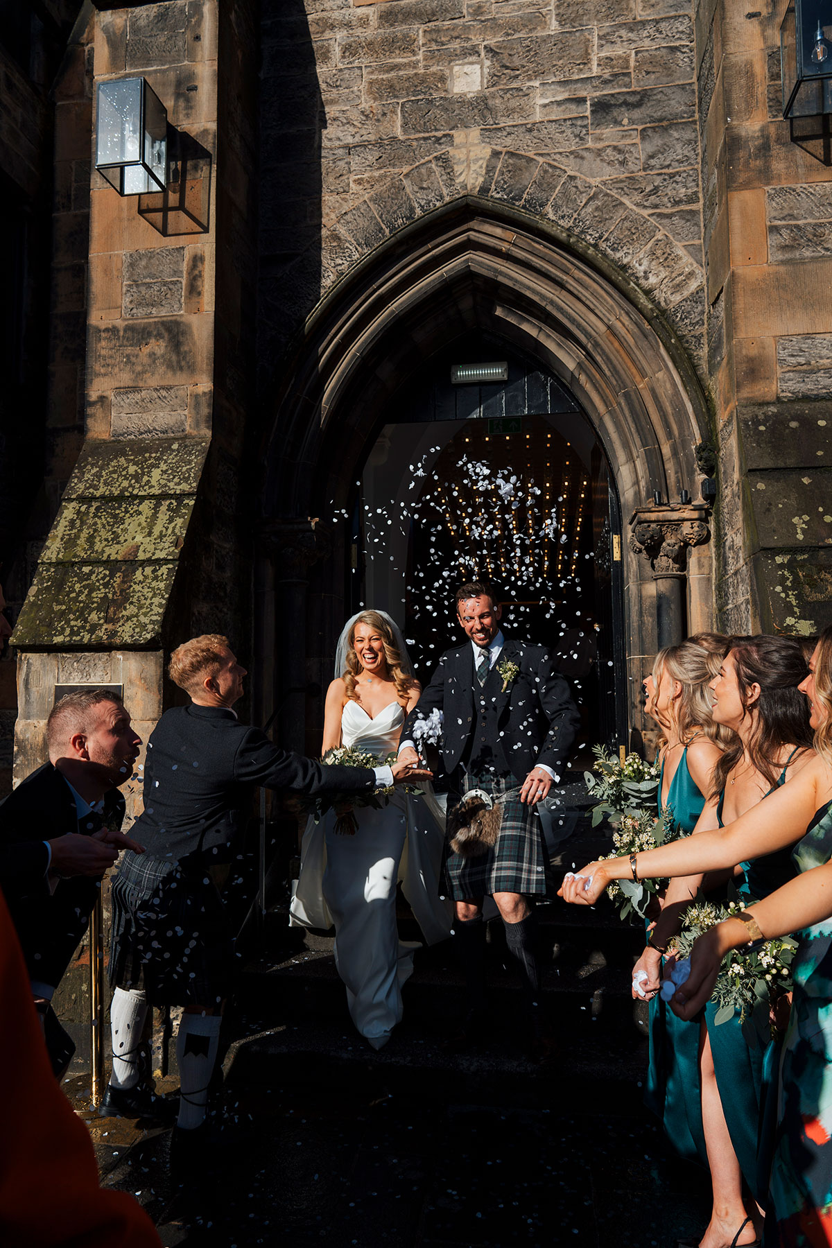 guests through confetti over bride and groom after wedding ceremony in edinburgh