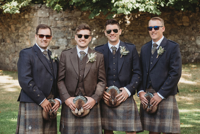 Groom and groomsmen in their kilts wearing sunglasses