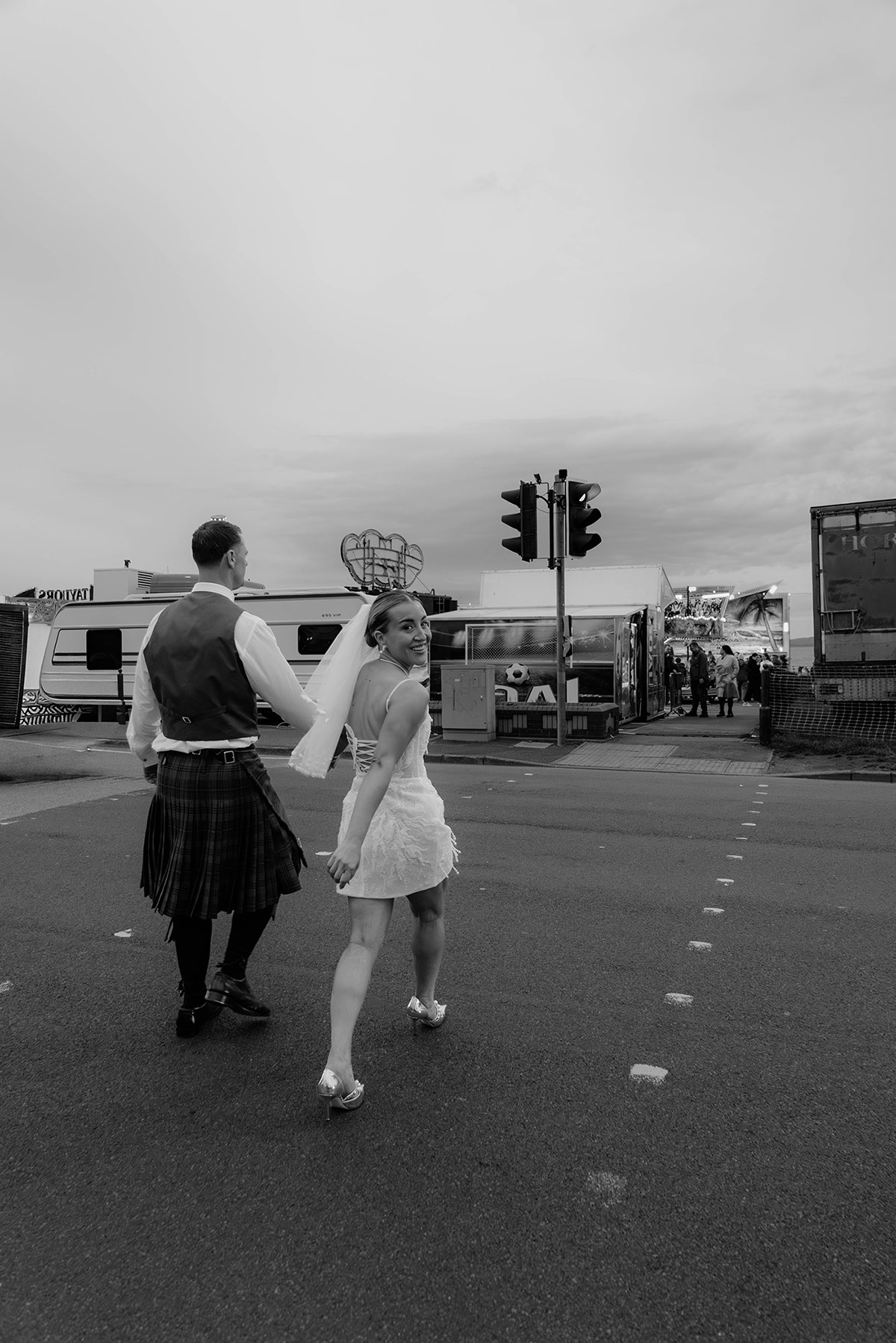 Bride and groom crossing the street together near Brisbane House Hotel in relaxed black and white wedding portrait