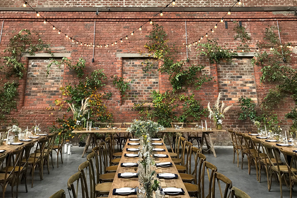 dinner set up with long tables and wooden chairs at the engine works in glasgow