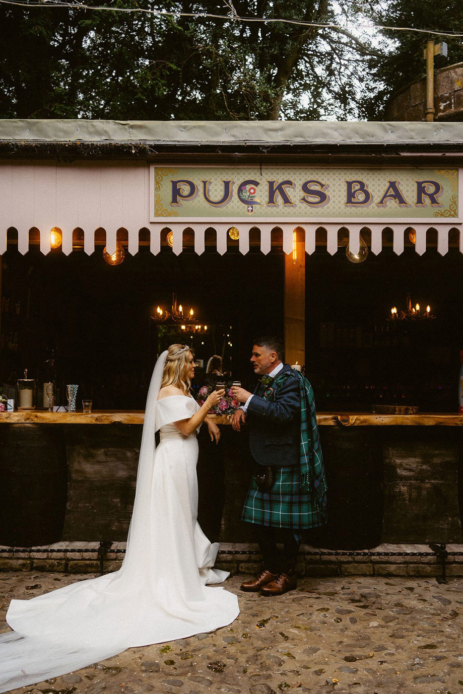 bride and groom cheers at pucks bar at culdees castle on their wedding day