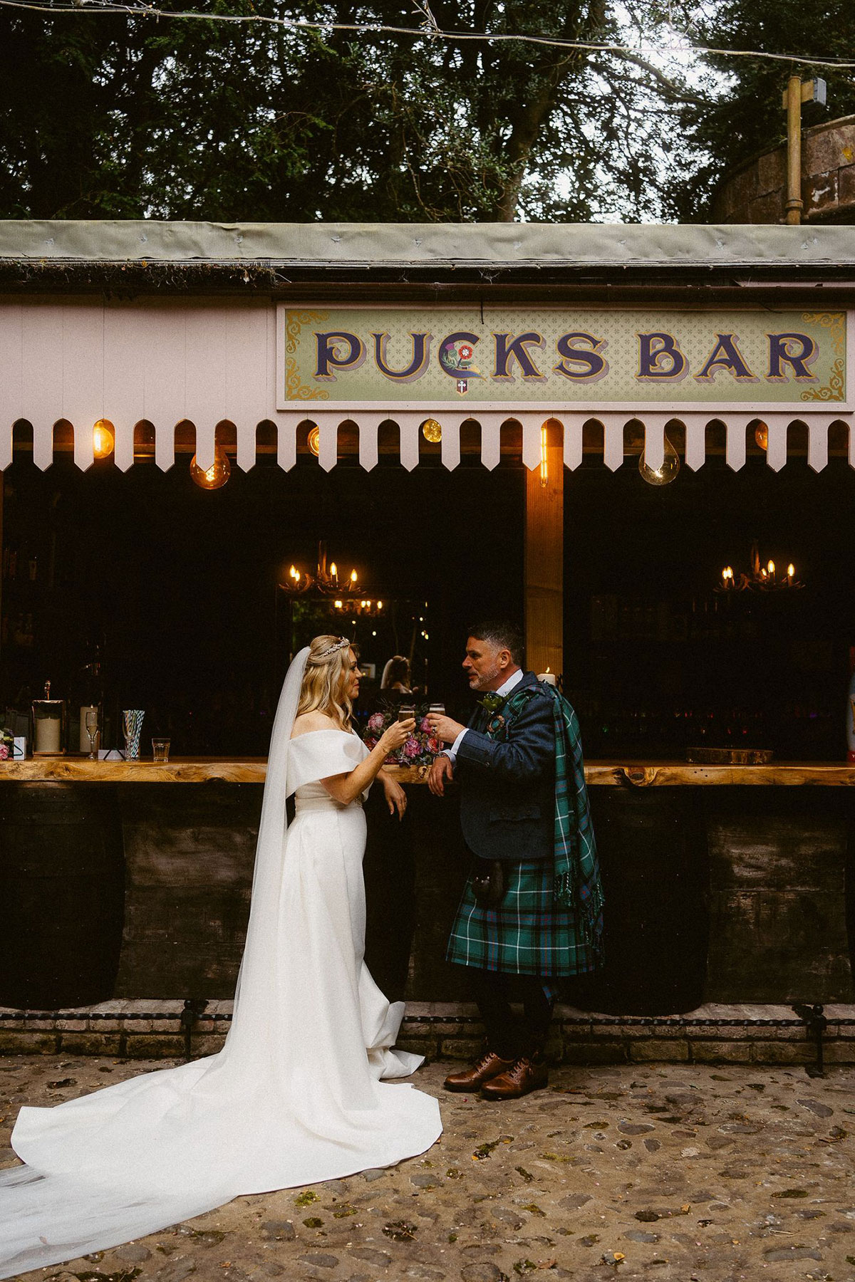 bride and groom cheers at pucks bar at culdees castle on their wedding day