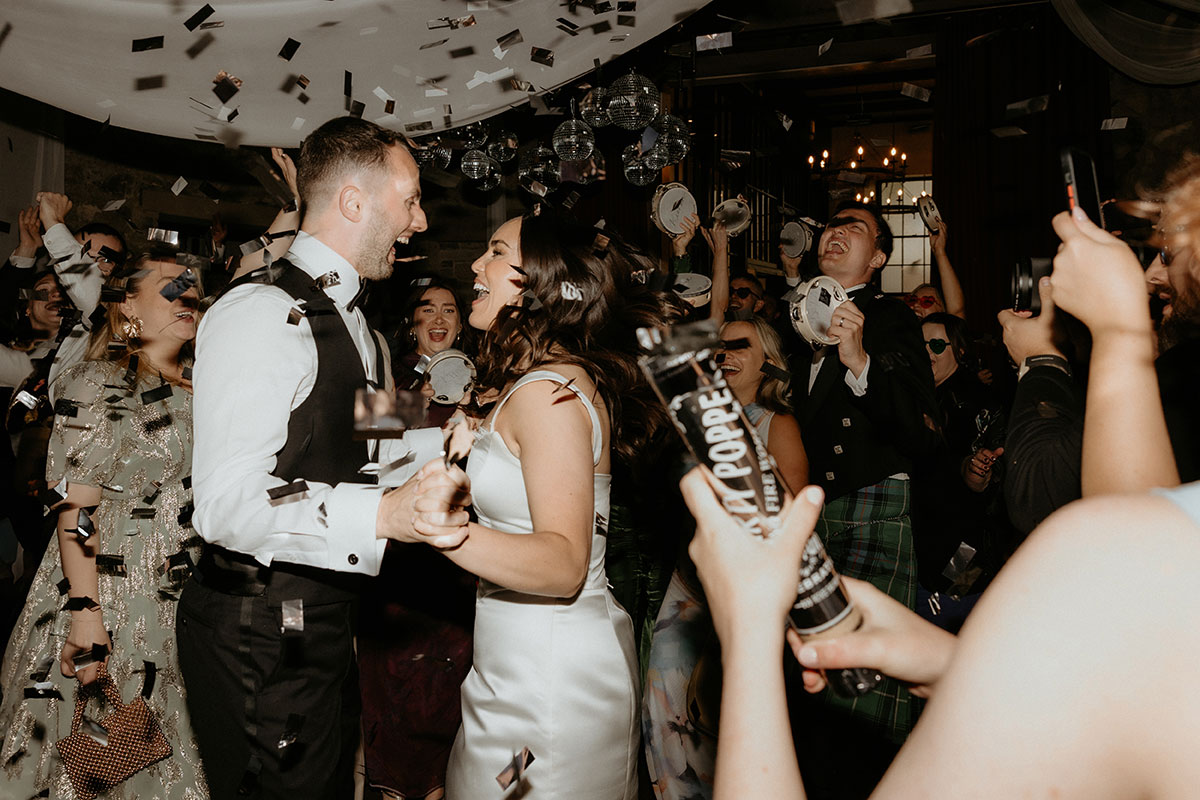 Bride and groom’s first dance with confetti cannons at Rosebery Steading reception, Midlothian wedding celebration.