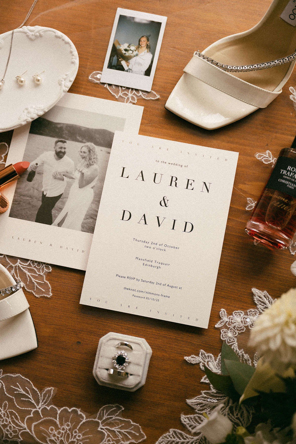 wedding flat lay with invitation stationery bridal shoes jewellery perfume and lace details