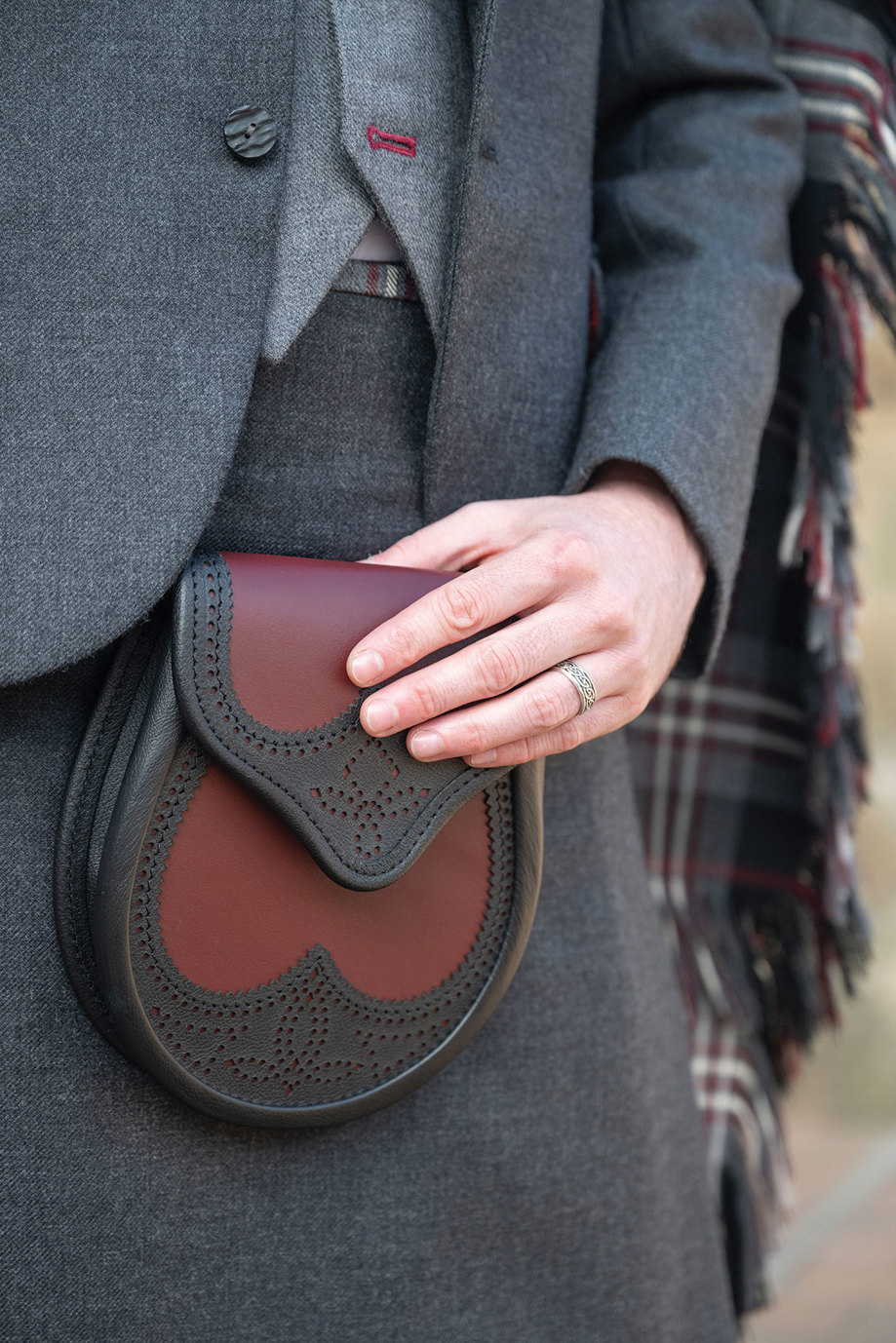 an oxblood and black brogue sporran on a grey plain kilt from Eight Yards