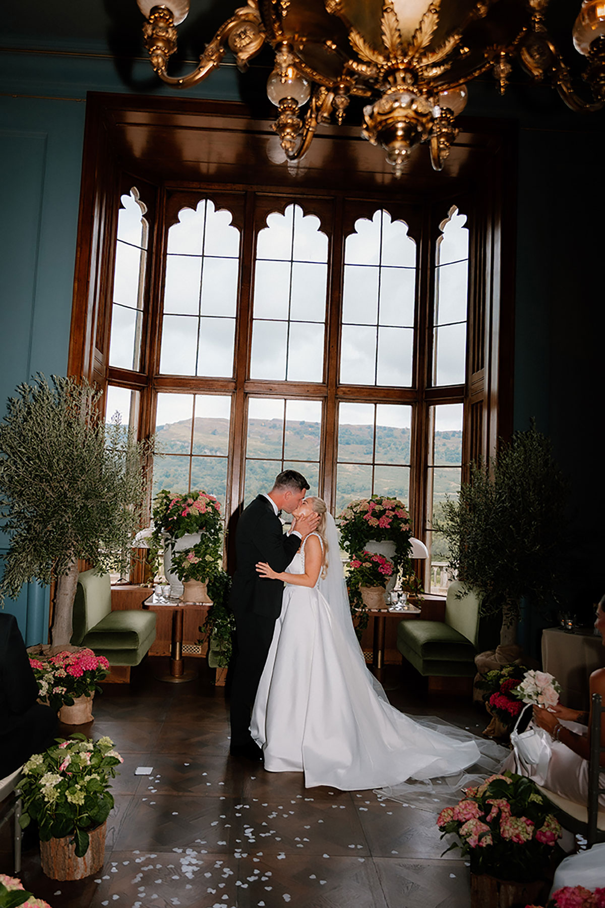 Bride and groom sharing their first kiss at the altar inside Mar Hall with floral decor around them.