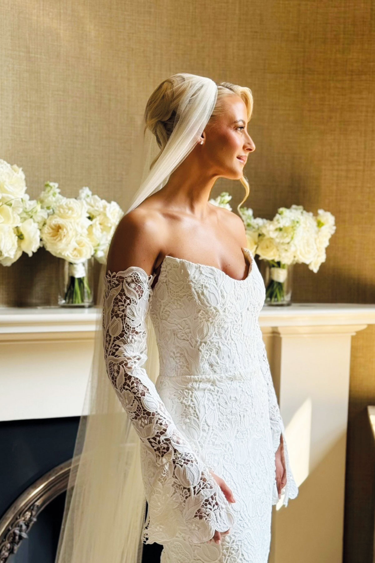Bride wearing a lace wedding dress and veil with softly styled hair and natural bridal makeup