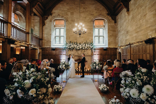 ceremony set up for couple at Achnagairn Castle with large floral displays