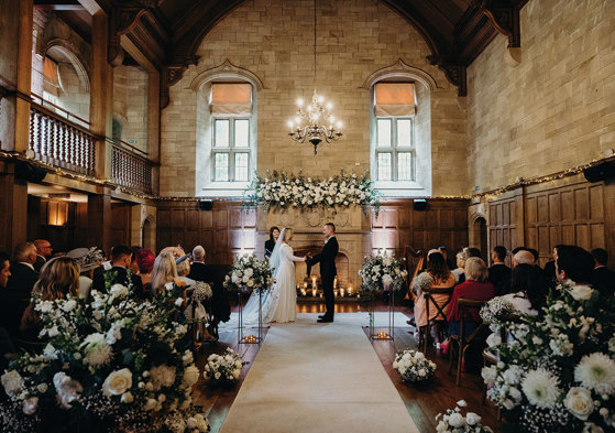 ceremony set up for couple at Achnagairn Castle with large floral displays