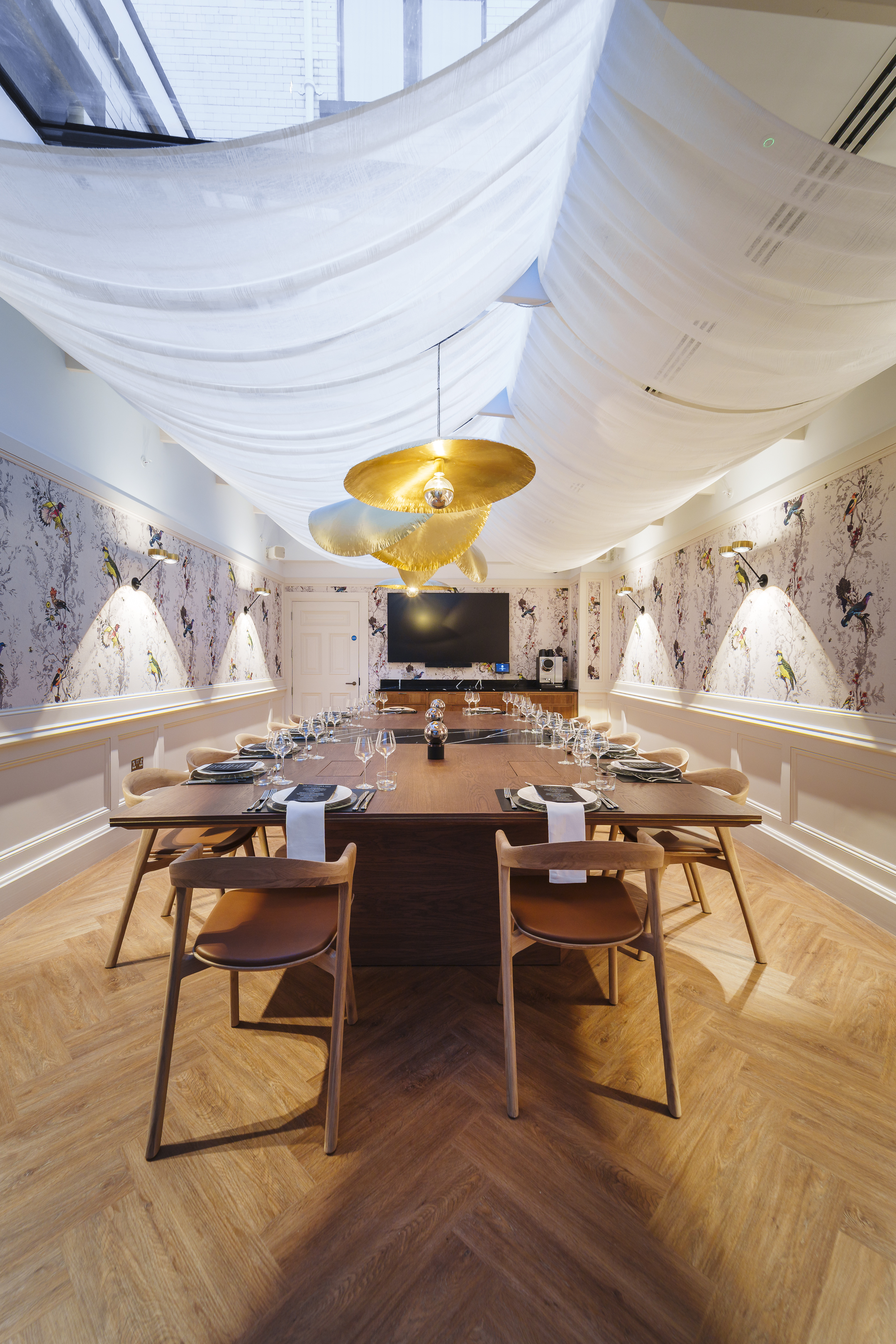 the treasury room at the collector's hall with large rectangle wooden table and bird printed wallpaper