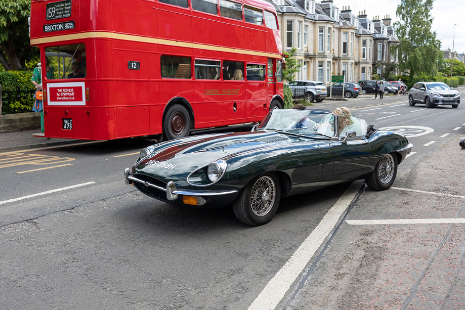 Bride and groom drive off in black vintage car