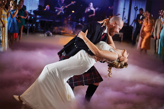 Bride and groom dancing surrounded by smoke