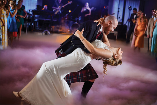 Bride and groom dancing surrounded by smoke